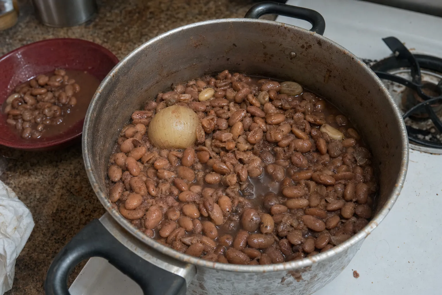 玉ねぎとにんにくと一緒に煮上がったピントビーンズの鍋。奥の器にも煮豆を取り分けてある